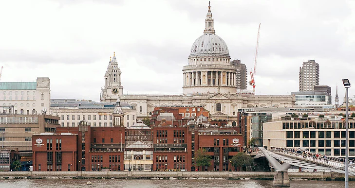 Londra manzarası: St. Paul Katedrali, nehir, mavnalar ve pankartların yanındaki insanlar
